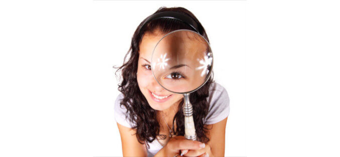 Woman with magnifying glass trying to find mystery shopping service providers